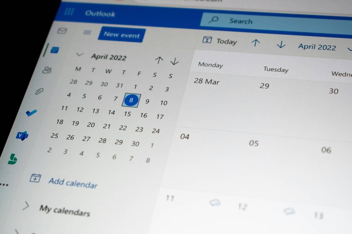 Smart clock calendar display mounted on wall beside bed showing morning schedule with soft ambient lighting