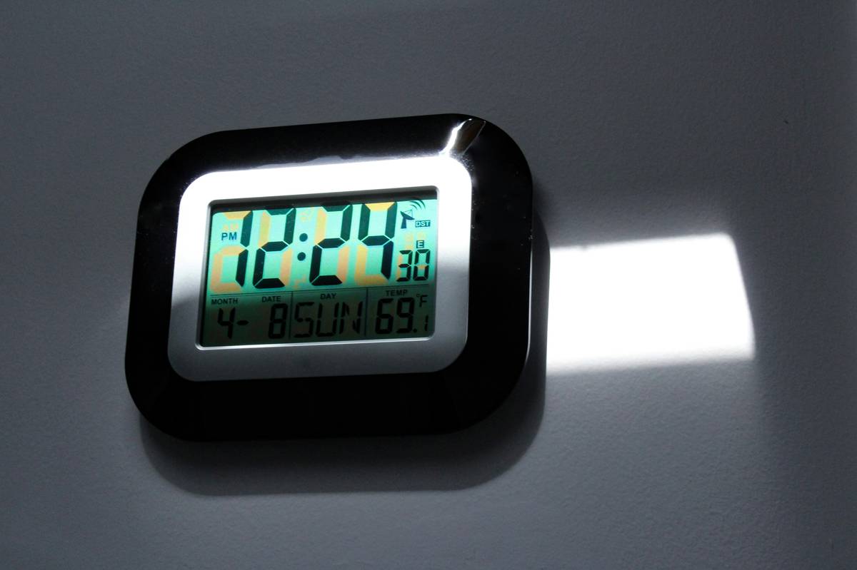 E-Ink smart clock calendar display showing clean daily agenda with bold date and minimal typography